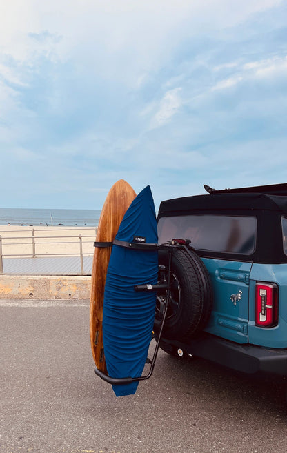 Turquoise SUV at the beach with two surfboards on RadRack